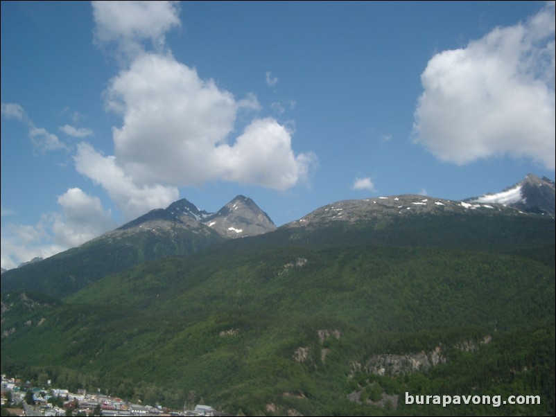 View of green mountains and blue skies from inside helicopter, Skagway.