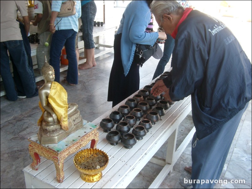 Putting coins into bowls, Wat Phra Mongkol Bophit.