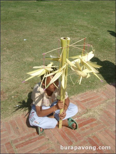 Kid selling grasshopper toys made out of bamboo, Wat Phra Mongkol Bophit.