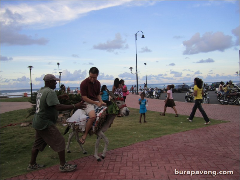 Riding donkey outside of fort.